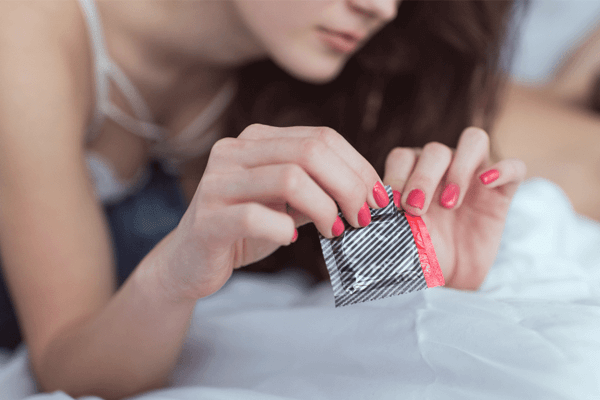 Žena thrající obal kondomu